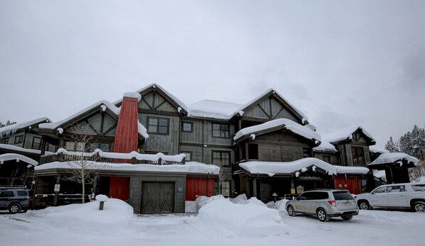 A large, multi-story wooden building with snow-covered roofs and a red chimney. - Copper Mountain -Spacious 1st Flr 2&2 near ski school/rentals,lift, hot tub (Copper Mountain)