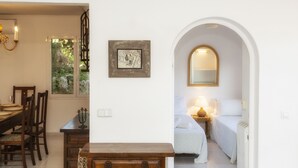 Una habitación con cama, mesita de noche y ventana con vistas a zonas verdes.