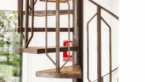 Una escalera de caracol con barandilla de metal y escalones de madera.