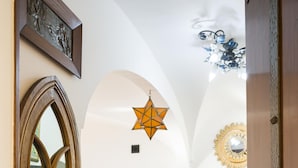 A corridor with a white sofa, a star-shaped light fixture, and a mirror on the wall.