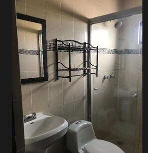 A bathroom with a sink, toilet, and a glass shower enclosure. - Departamentos Enki Centro (Cajeme)