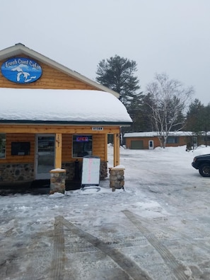 Café Fresh Coast con fachada de madera y techo cubierto de nieve.