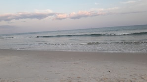 A beach with gentle waves and a clear sky.