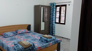 Un dormitorio con cama, armario, ventana con cortinas y puerta.