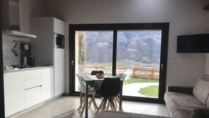 A modern kitchen with a dining area and a sofa.