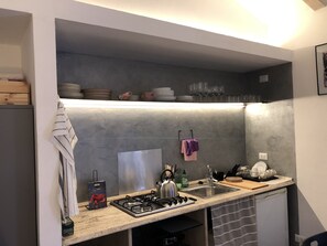 Een koelkast, een microgolfoven, een kookplaat, een waterkoker