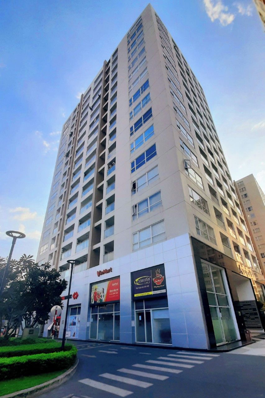 Un edificio de varios pisos con una planta baja comercial que incluye un restaurante y una cafetería.