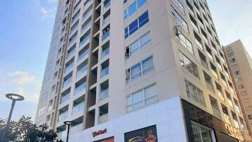 Un edificio de varios pisos con una planta baja comercial que incluye un restaurante y una cafetería.