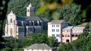 Una iglesia histórica con un campanario y edificios residenciales adyacentes.