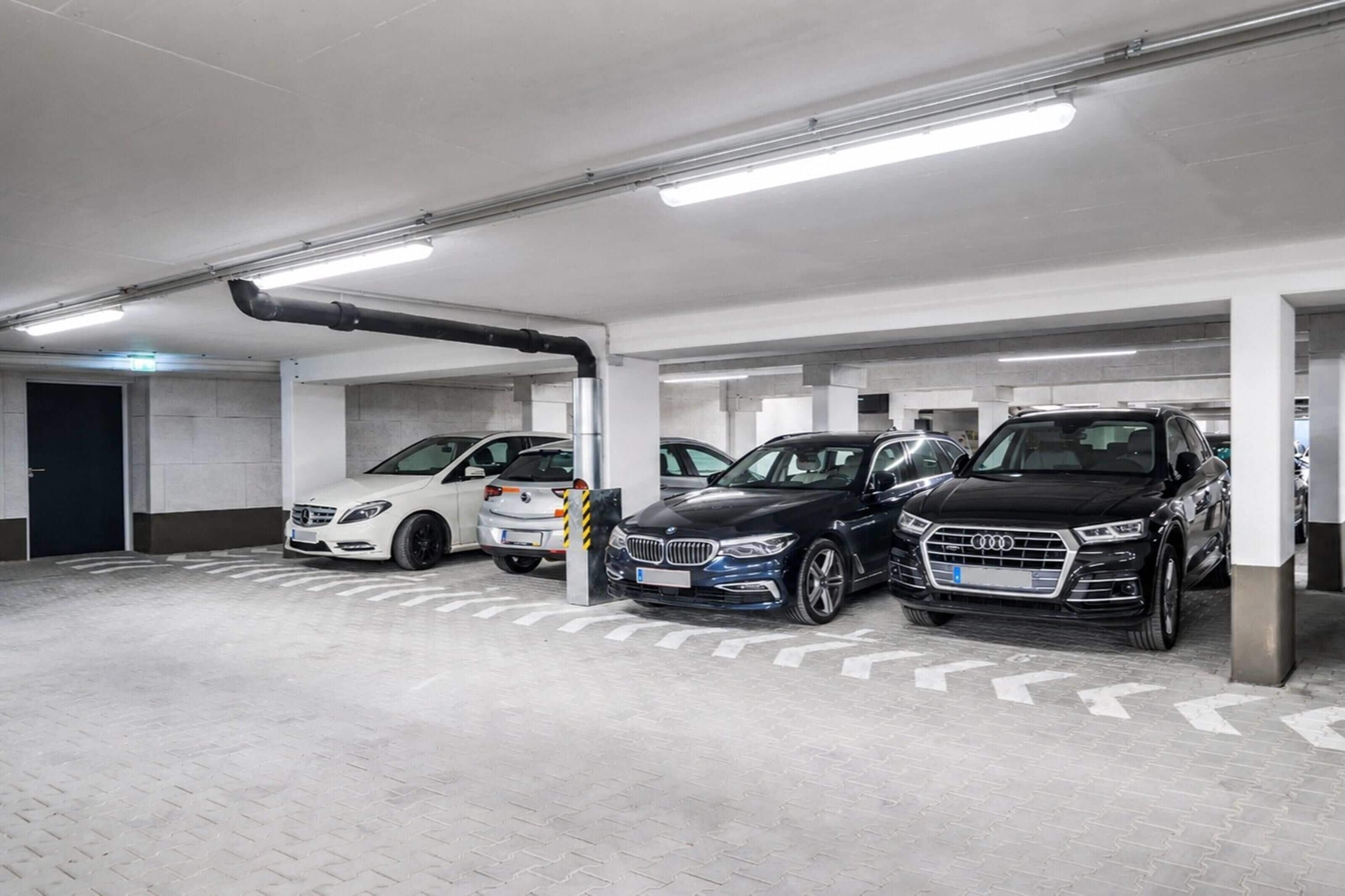 Un estacionamiento subterráneo de varios niveles con varios coches estacionados.