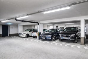 Un parking souterrain à plusieurs niveaux, où plusieurs voitures sont garées.