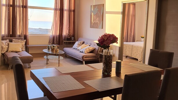 A modern living room with a dining area, a sofa set, a coffee table, and a view of the sea. - New beautiful Ocean View Apartment (Tijuana)