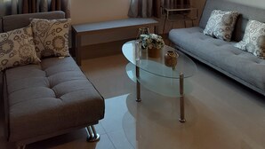A living room with a sofa, a glass coffee table, and a view of the sea. - New beautiful Ocean View Apartment (Tijuana)
