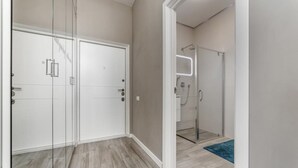 A room with a shower, a door, and a blue rug. - Sunset lovers in Odessa (Odessa)