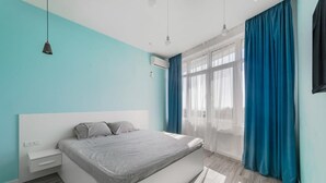 A modern bedroom with a bed, bedside table, and a window with curtains. - Sunset lovers in Odessa (Odessa)