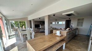 A spacious kitchen with a wooden countertop, a dining area with chairs, and a large window. - VILLA sea view, panoramic view, 8 pers fréjus  (Fréjus)