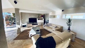A modern living room with a large sectional sofa, a flat-screen TV, and a coffee table. - VILLA sea view, panoramic view, 8 pers fréjus  (Fréjus)