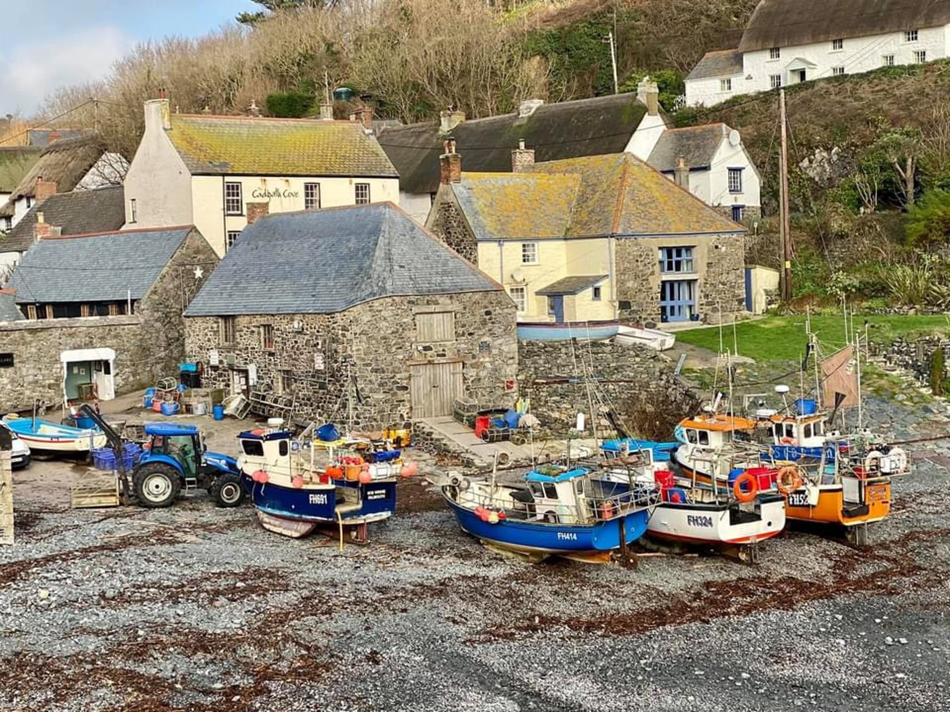 A coastal village with stone buildings and boats docked at the shore.