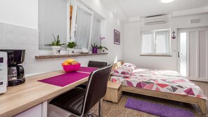 A modern bedroom with a wooden bed, a desk with a chair, a coffee machine, and potted plants. - Awesome apartment in Rukavac with WiFi (Rukavac)