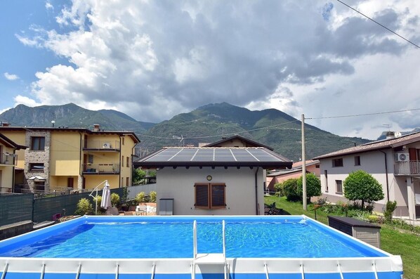 Una piscina con montañas al fondo, rodeada de edificios residenciales.