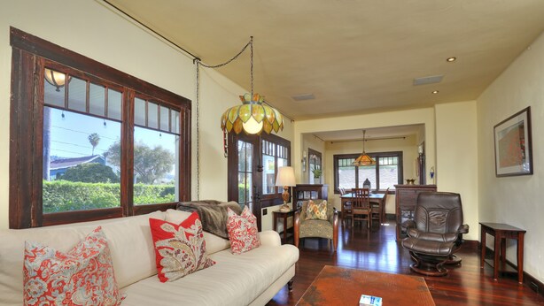 A spacious living room with a large sofa, two armchairs, a coffee table, and a dining area in the background. - Downtown Craftsman Bungalow (Santa Barbara)