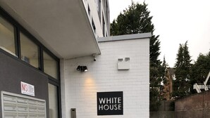Valkoinen rakennus, jonka yläpuolella on kyltti, jossa lukee ”WHITE HOUSE”, ja metallinen portaikko, joka johtaa sisäänkäyntiin.