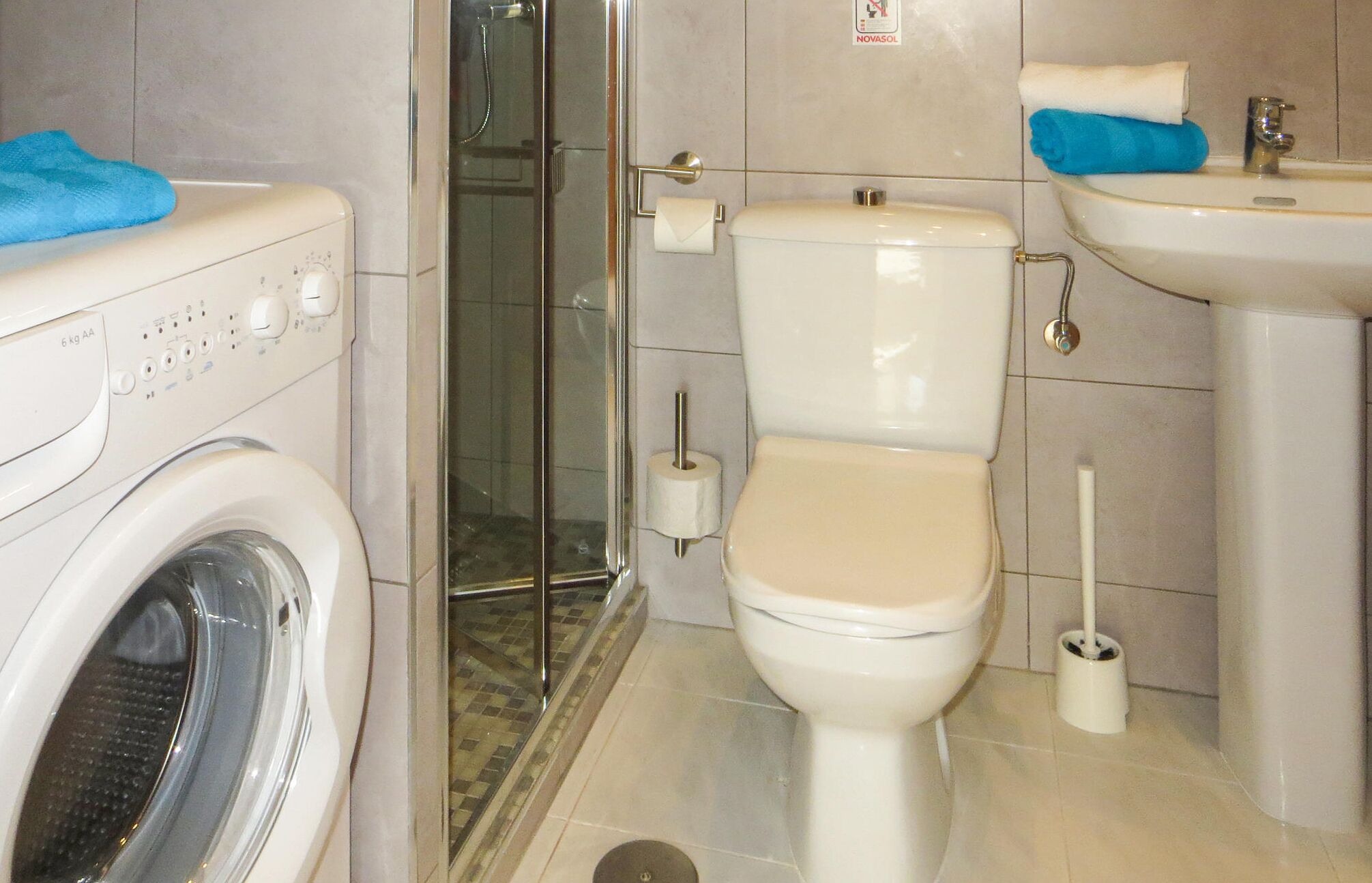 Ein Badezimmer mit Waschmaschine, Toilette und Waschbecken.