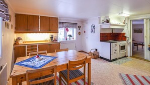 Una cocina acogedora con armarios de madera, una mesa de comedor con sillas y un horno pequeño.