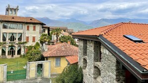 Un bâtiment traditionnel avec un toit recouvert de tuiles rouges, des murs en pierre et un petit balcon.