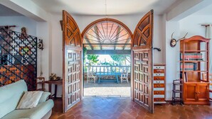 Una habitación con puerta de madera que da a un patio exterior con mesa y sillas.