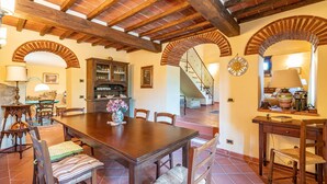 A dining area with a wooden table and chairs, a cabinet with glass doors, and a staircase leading to another level. - Gorgeous home in Monte San Savino with WiFi (Monte San Savino)