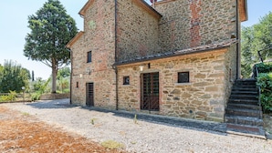 A stone building with a traditional design, featuring multiple windows and a staircase leading to the upper floor. - Gorgeous home in Monte San Savino with WiFi (Monte San Savino)