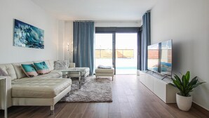 A modern living room with a sofa, coffee table, and TV. - Beach front home in Los Alcázares (Los Alcázares)