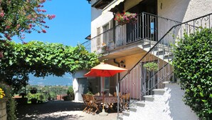 Un edificio con un balcone, posti a sedere all'aperto e vista sul paesaggio.