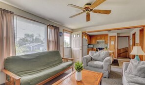 Relax in this cozy space with a sofa by the window, a kitchenette, and a separate room for dining or sleeping.