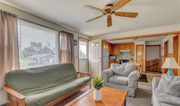 Relax in this cozy space with a sofa by the window, a kitchenette, and a separate room for dining or sleeping.
