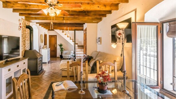 Amplia sala de estar con chimenea, televisor y mesa de comedor con sillas.