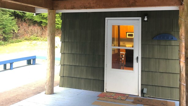 Un porche cubierto de madera con una puerta que da a una habitación.