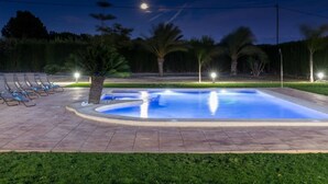 A swimming pool with a tiled deck, surrounded by palm trees and a row of lounge chairs. - Fidalsa Dom Perignon (Crevillente)