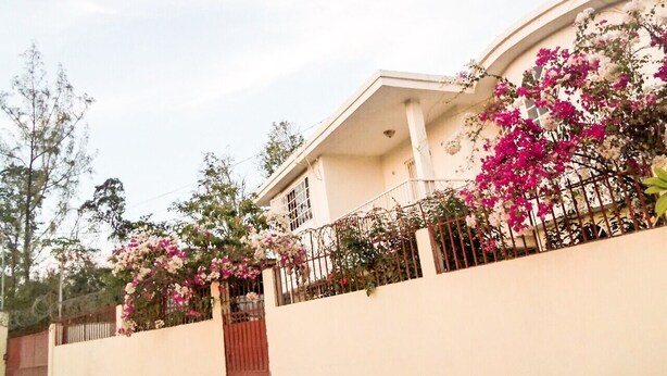 A house with a curved roof, a white exterior, and a gated entrance. - Vacation rental house (Arrondissement de Jacmel)