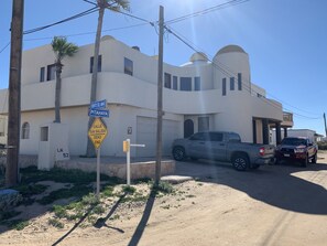 A modern building with a curved facade, a garage, and two parked trucks.