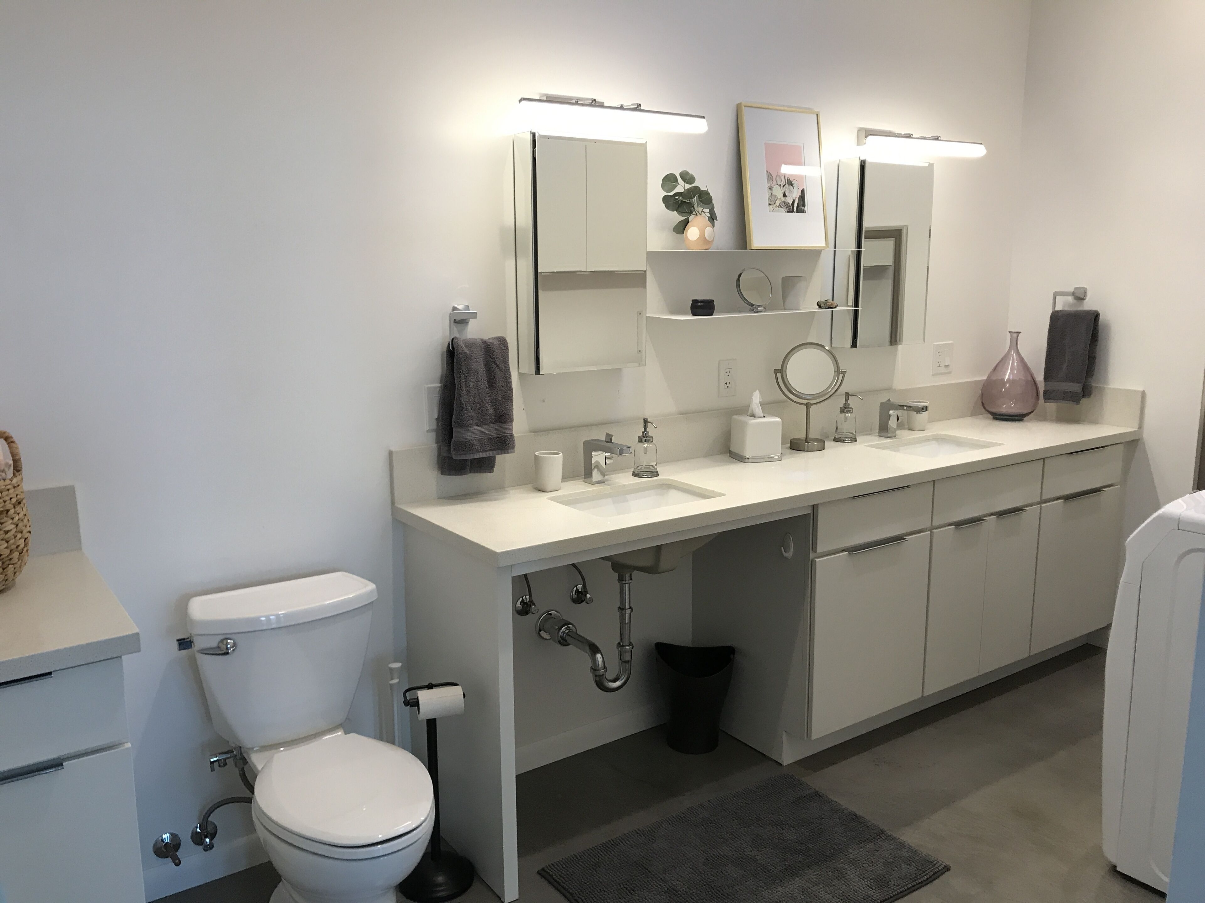 Une salle de bain moderne avec des toilettes, un lavabo et un miroir.