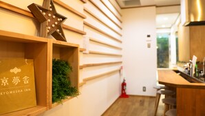A hotel interior with wooden shelves, a star decoration, and a sign reading "KYOMUSHA INN". - Kyomusha Inn (Kyoto)