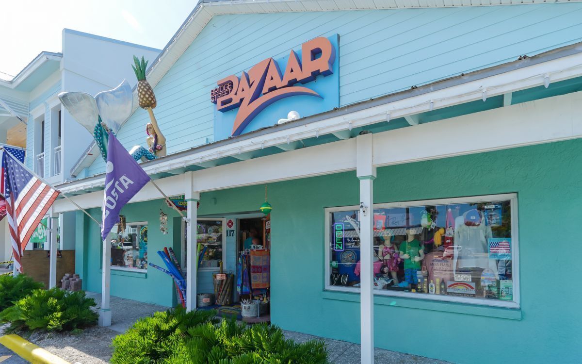 A storefront with a 'BZAAR' sign, a pineapple decoration, and a purple flag.
