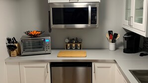 Une cuisine équipée d’un four à micro-ondes, d’un grille-pain, d’une machine à café et d’un lave-vaisselle.