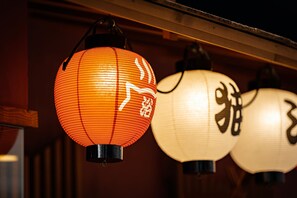 Eine Reihe traditioneller Laternen mit japanischen Schriftzeichen, die in einer Reihe hängen.