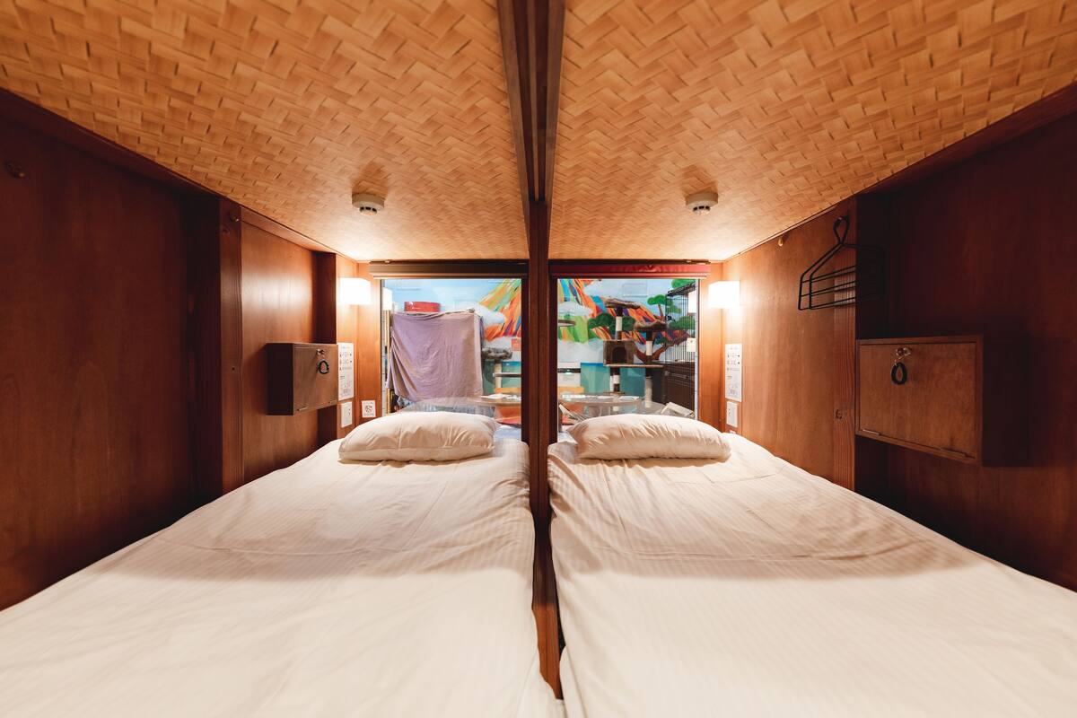 A mirrored room with two beds, wooden walls, and a ceiling with a brick pattern.