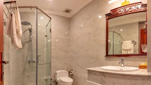 A modern bathroom with a glass-enclosed shower, a toilet, and a vanity with a mirror. - HANZ Premium Mai Vang 2 Hotel Dalat (Xuan Huong - Da Lat)