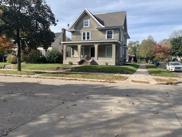 A two-story house with a front porch, a chimney, and a well-maintained lawn.