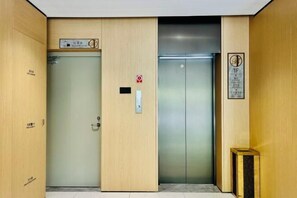 Un ascenseur d’hôtel avec un intérieur en bois et une pancarte indiquant le premier étage.
